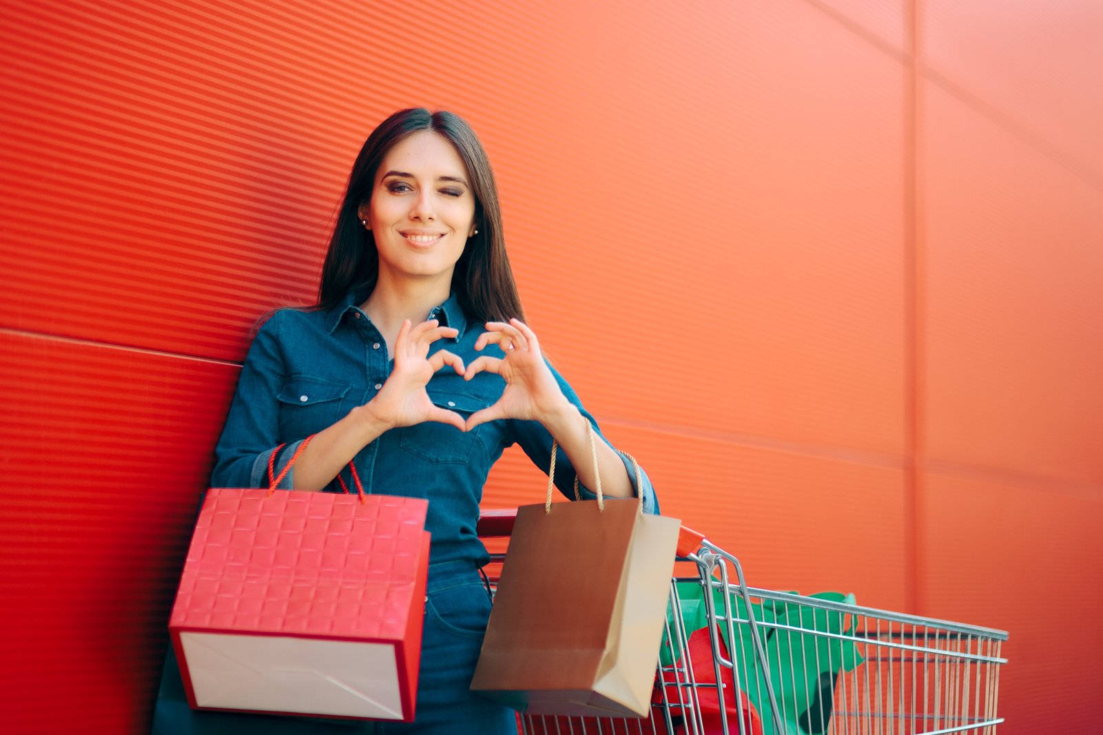 Happy Female Customer Doing Heart Sign After Shopping Spree